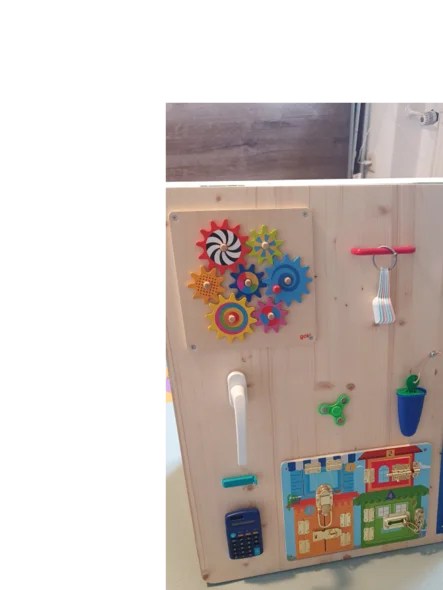 Ein Holzbrett mit verschiedenen bunten sensorischen Spielzeugen.