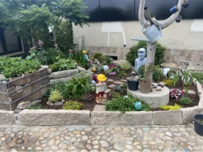 Bunter Garten mit Figuren und Steinen