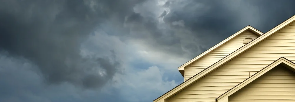 Gelbes Hausgiebel unter dunklem Himmel
