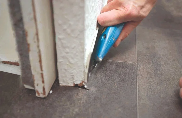 Person schneidet Boden mit Cuttermesser
