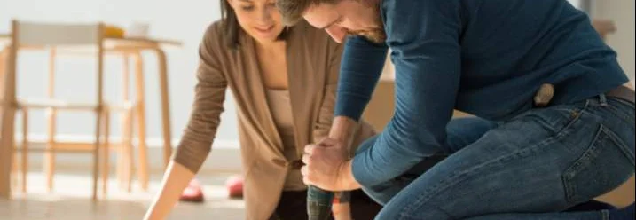 Zwei Personen bauen Möbel zusammen