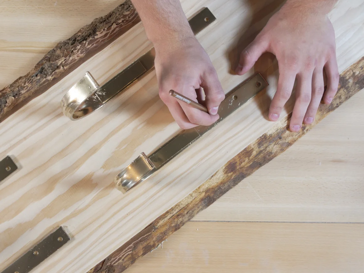 Person markiert Holz mit Bleistift
