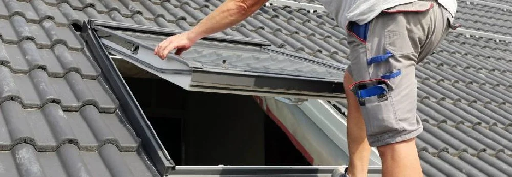 Person montiert Dachfenster