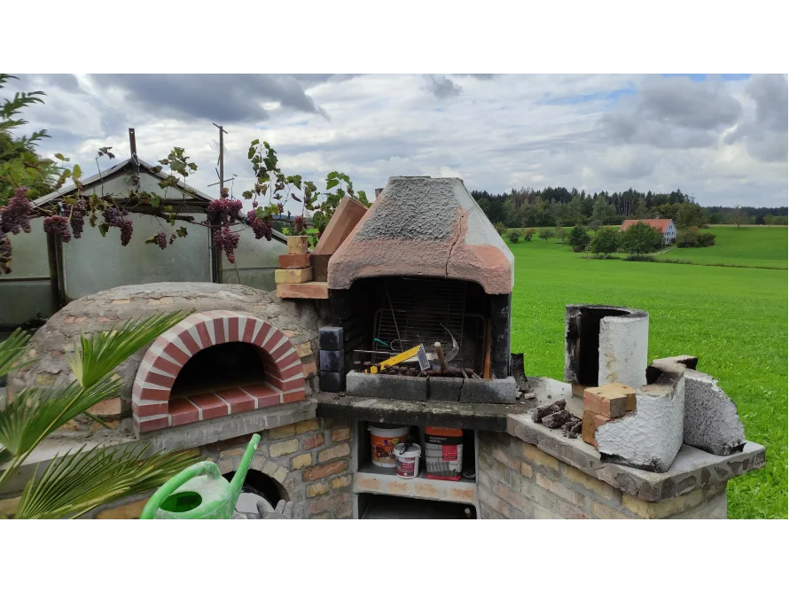 Ein gemauerter Pizzaofen im Garten.