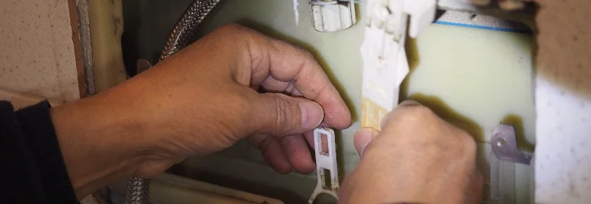 Hände reparieren einen Spülkasten
