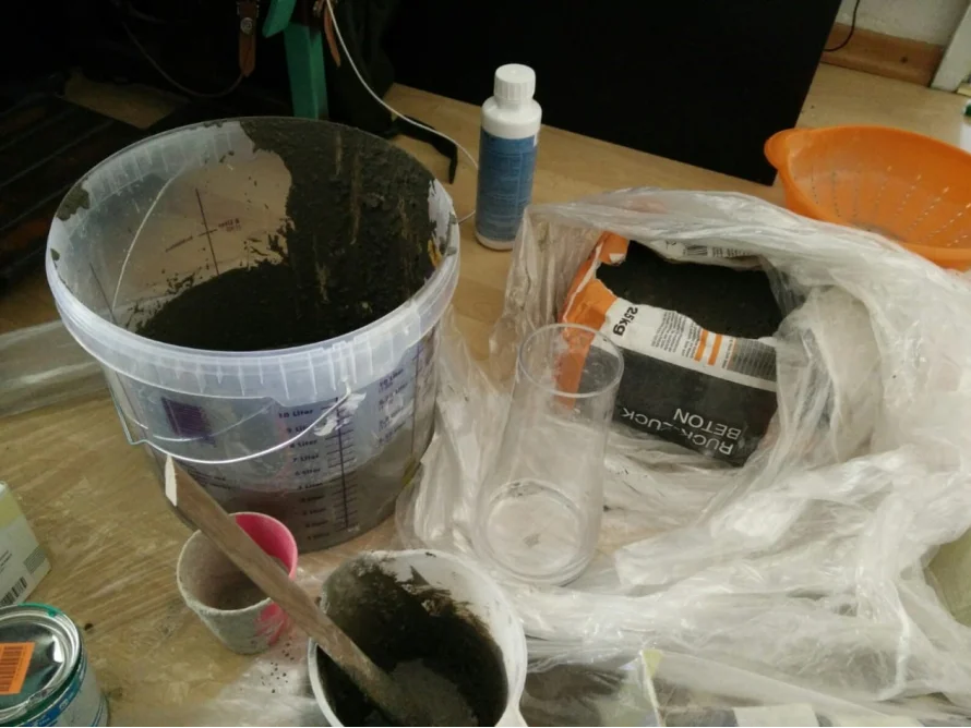 Beton wird in einem Eimer und einer Schüssel angerührt