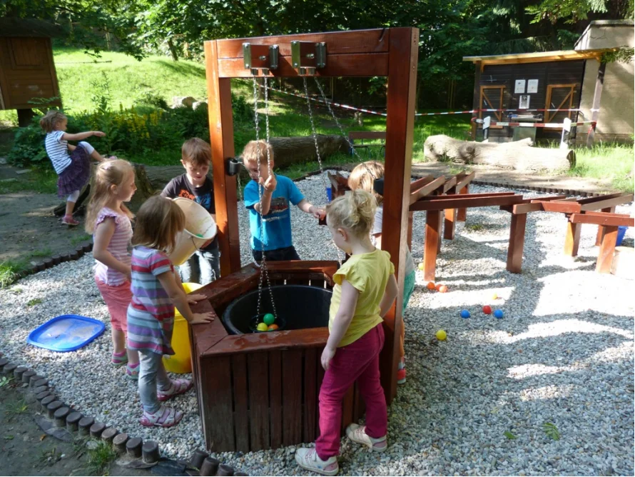 Kinder spielen mit Wasser und Bällen an einem Spielgerät