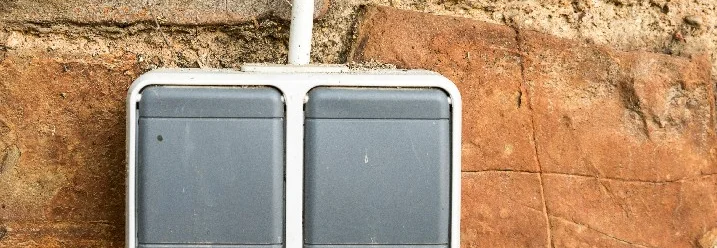 Doppelte Außensteckdose an Backsteinmauer