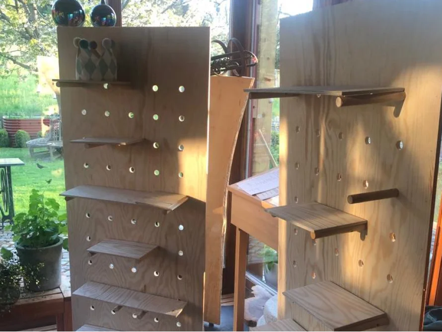 Zwei Regale aus hellem Holz mit Lochmuster
