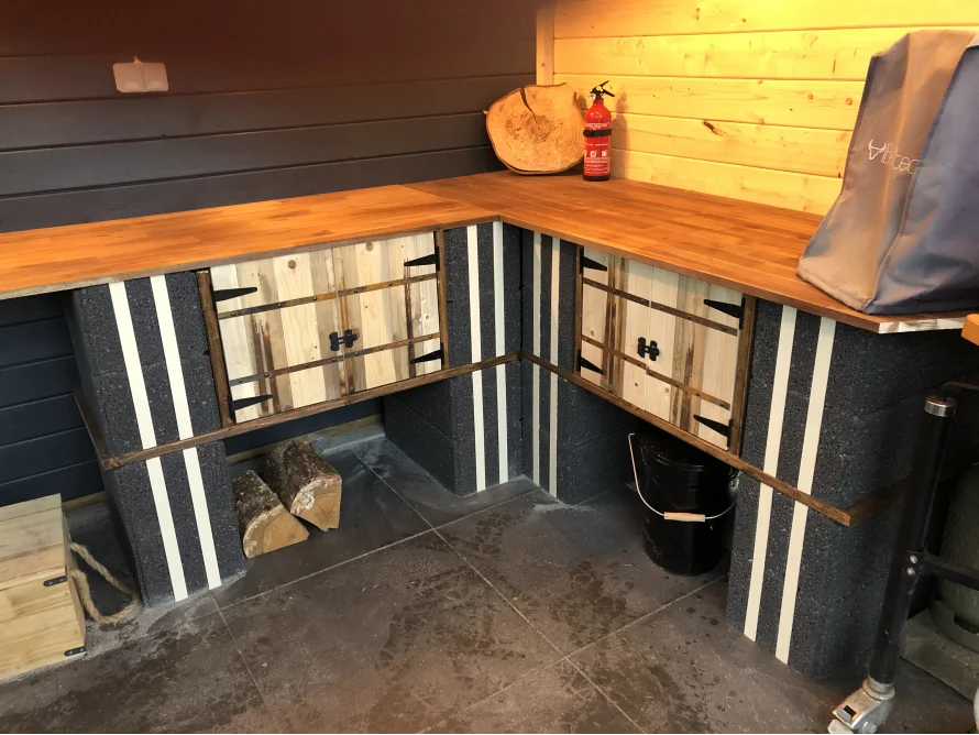 Ecke einer Außenküche aus Holz und Beton