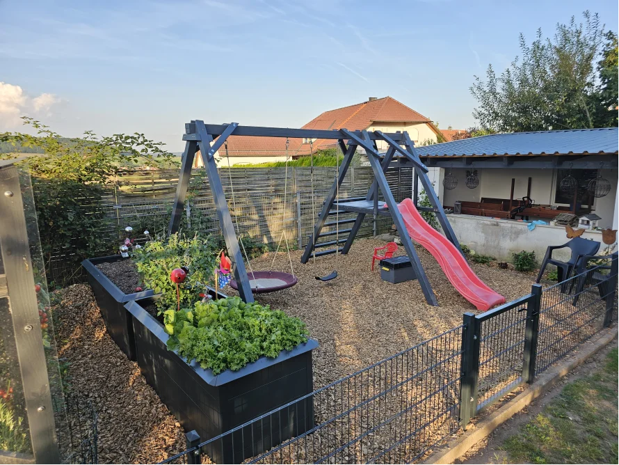 Spielplatz im Garten mit Schaukel und Rutsche