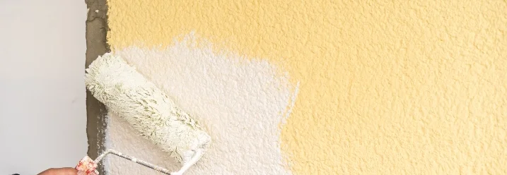 Person streicht Wand weiß