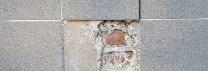 Beschädigte Fliese an einer Wand.