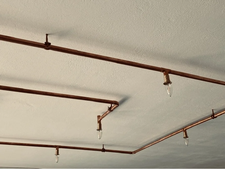 Kupferrohre mit Glühbirnen an Decke