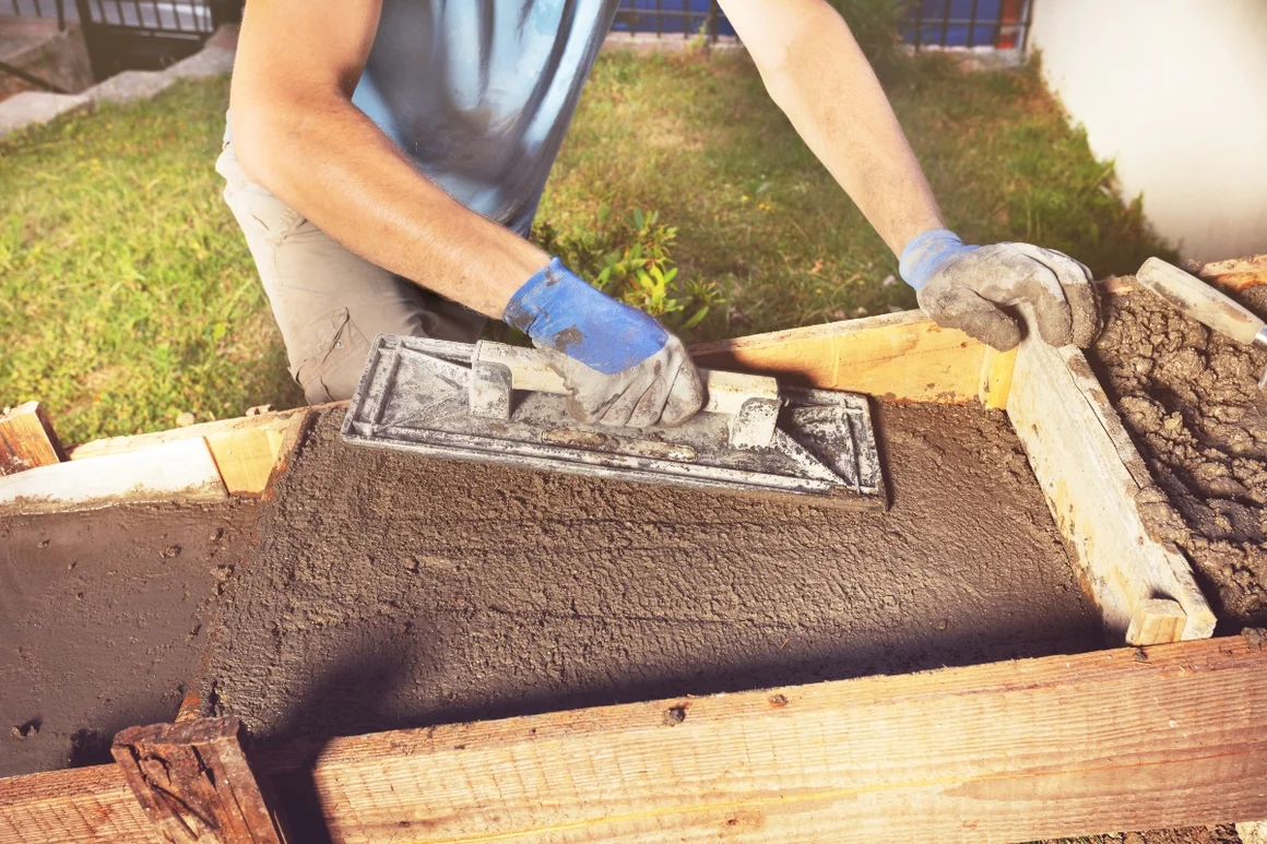 Person glättet Beton mit Glättkelle