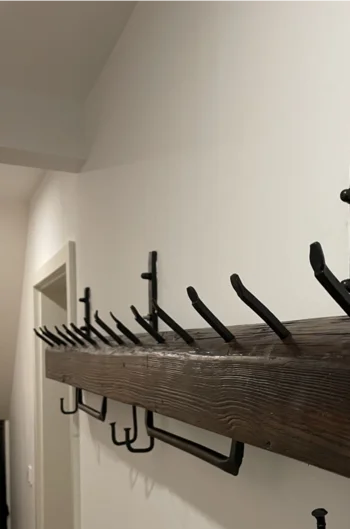 Garderobe aus dunklem Holz mit schwarzen Haken