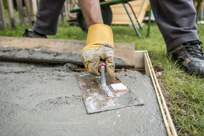 Person glättet Beton mit Kelle