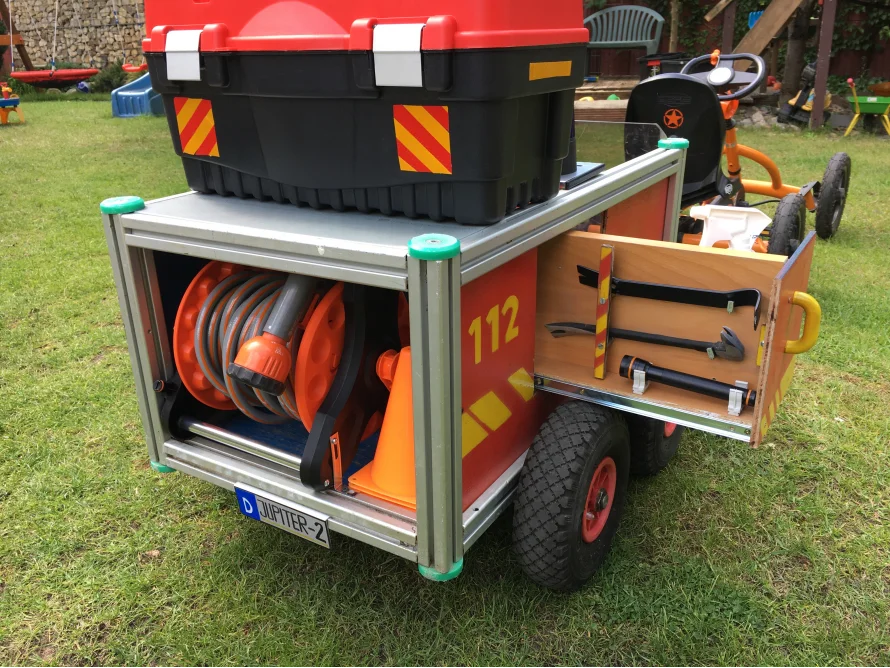 Spielzeugfeuerwehrwagen mit Schlauch und Axt