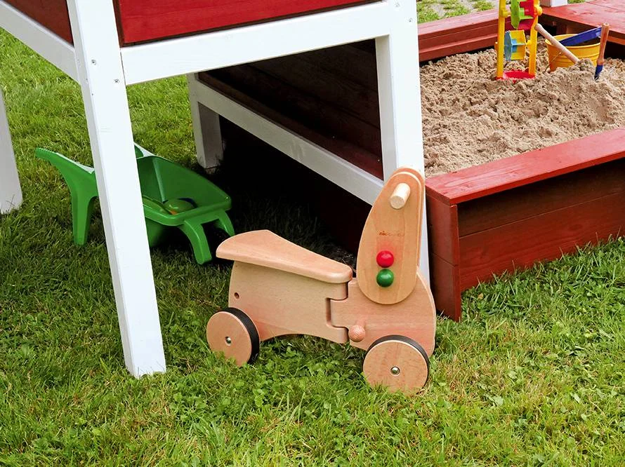 Spielzeugtraktor und Schubkarre im Garten