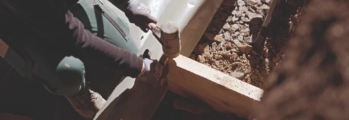 Person befestigt Holzbalken mit Hammer