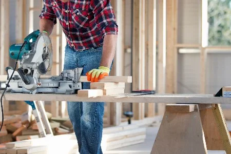 Person sägt Holz mit Kappsäge