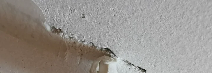 Riss in der Decke wird mit Dichtmittel gefüllt