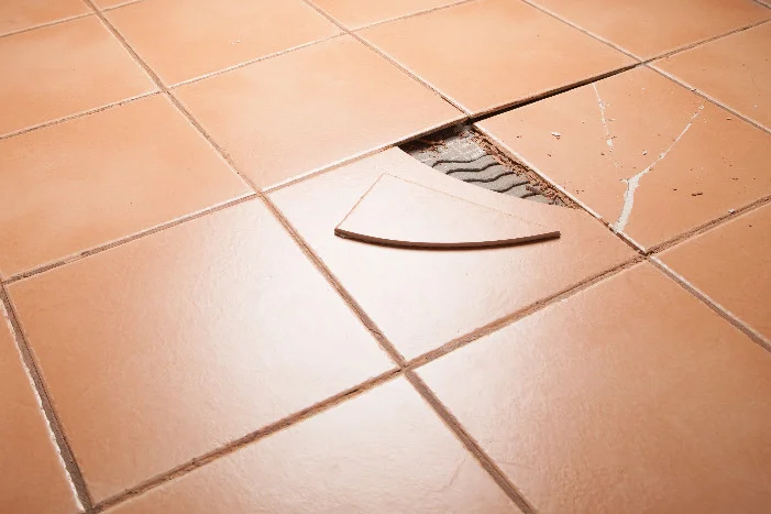 Kaputte Fliese auf Fliesenboden
