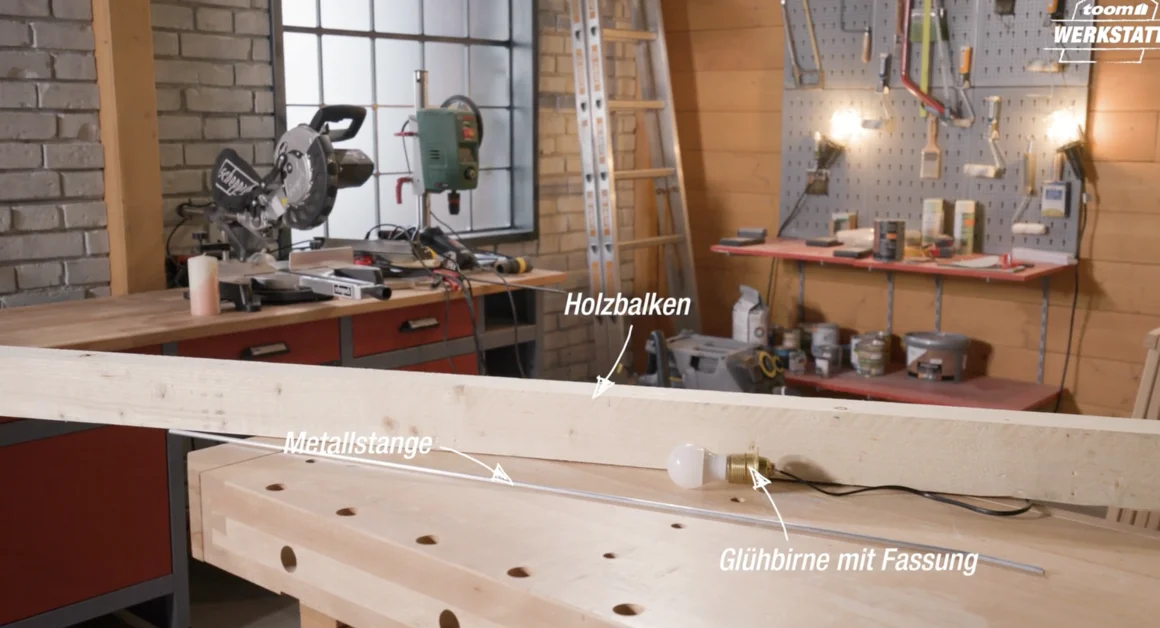 Holzbalken, Metallstange und Glühbirne auf Werkbank
