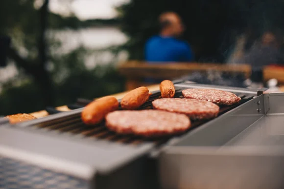 Bratwürste und Burger auf einem Grill