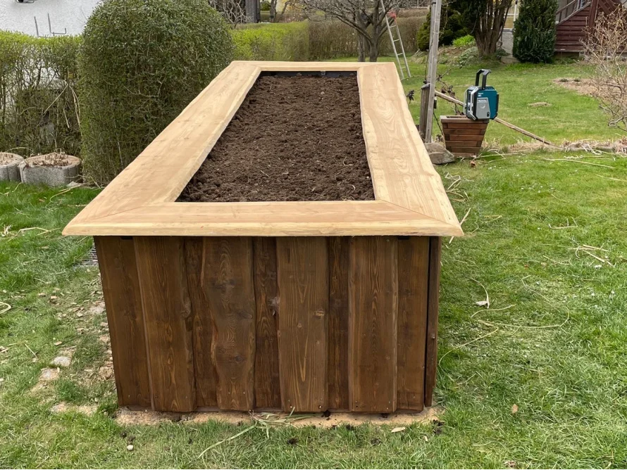 Hochbeet aus Holz mit frischer Erde