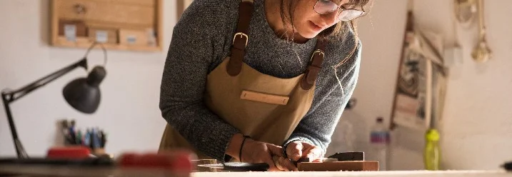 Person hobelt Holz
