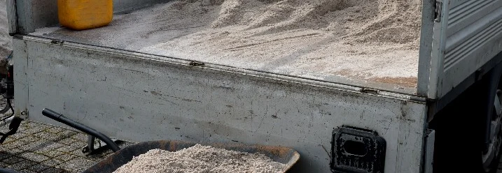 Anhänger und Schubkarre mit Sand