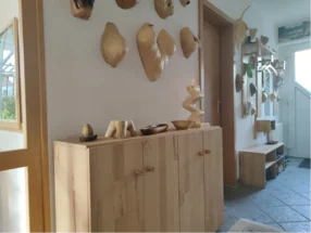 Ein Flur mit einem Sideboard und Dekorationen aus Holz.