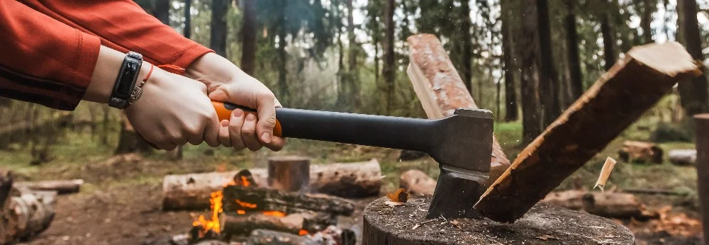 Person hackt Holz mit Axt