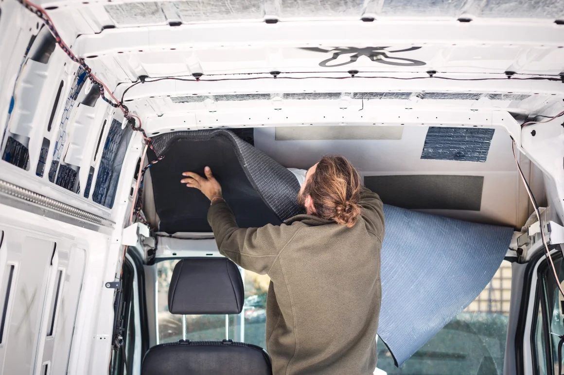 Person bringt Dämmmaterial in Transporter an