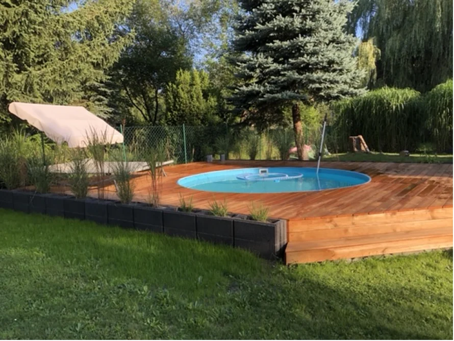 Runder Pool auf Holzterrasse im Garten
