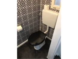 Toilette mit schwarz-weiß gemusterter Wand