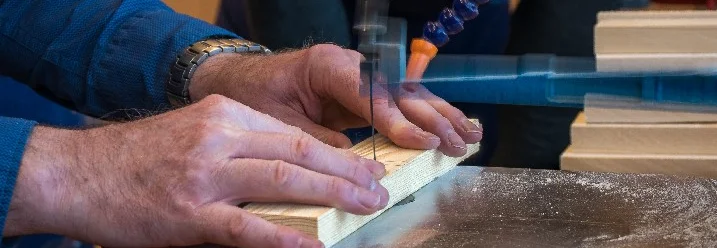 Person sägt Holz mit Dekupiersäge