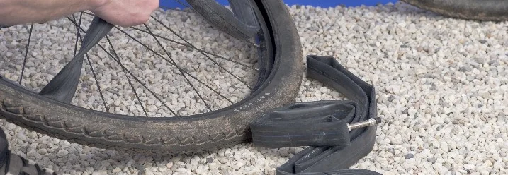 Person zieht Fahrradschlauch aus Reifen