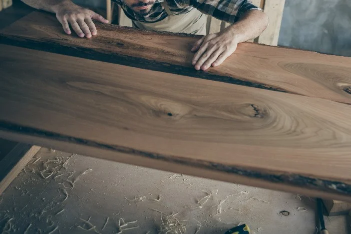 Person berührt eine große Holzplatte