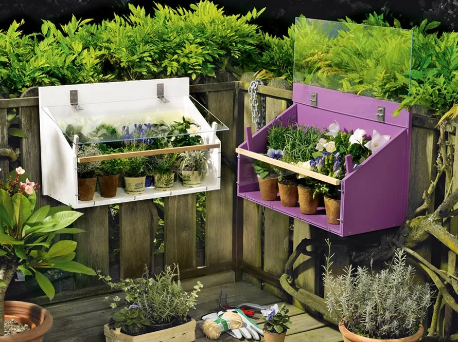 Zwei Blumenkästen an einem Gartenzaun