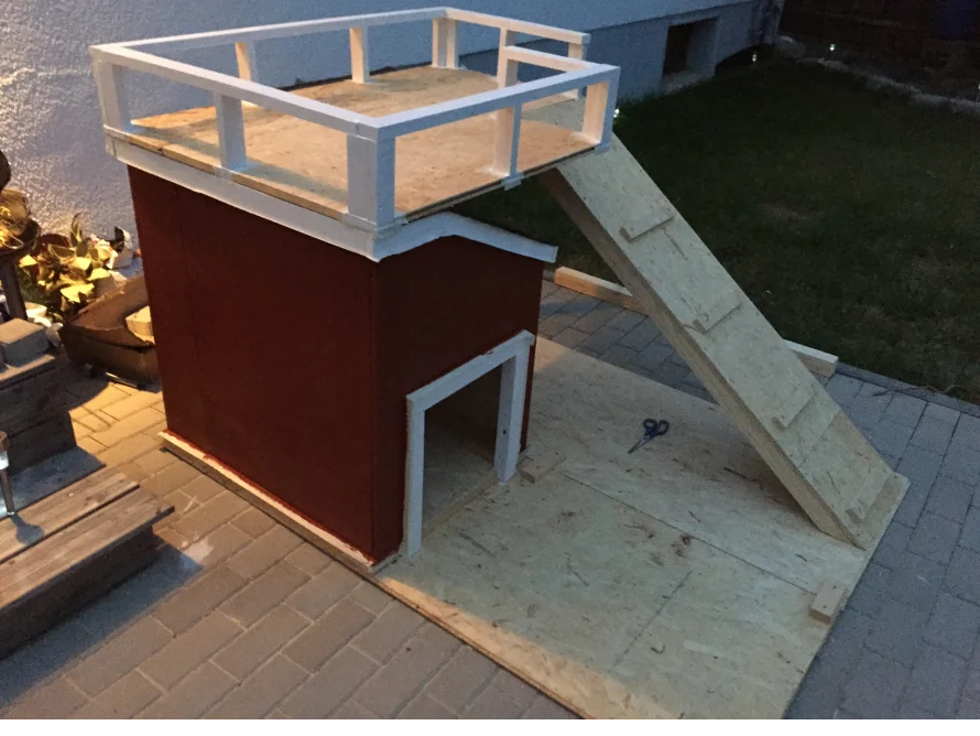 Rote Hundehütte mit Veranda und Rampe