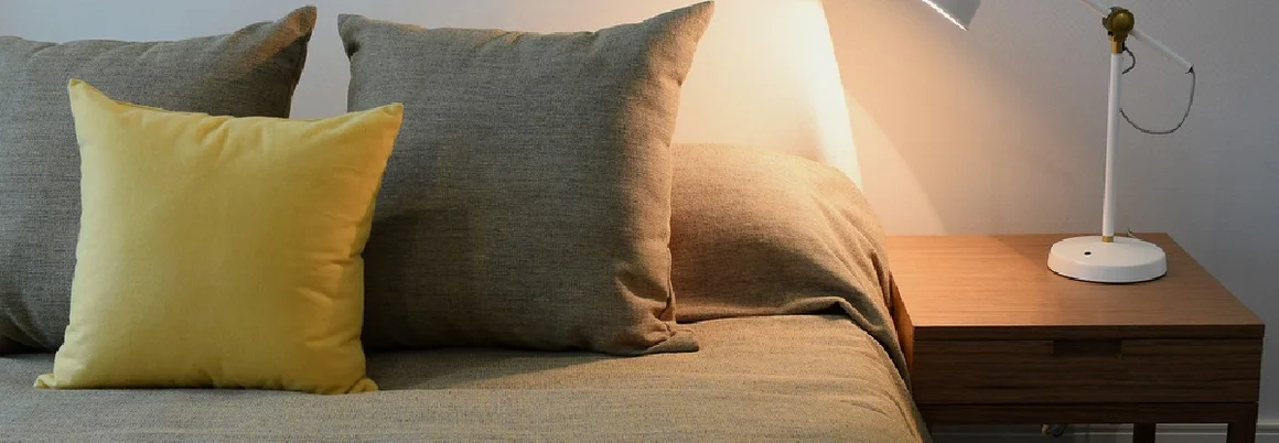 Gemachtes Bett mit Leselampe auf Nachttisch