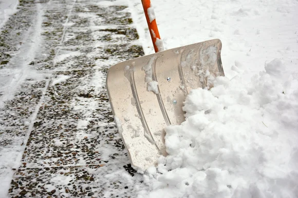 Schneeschaufel räumt Schnee von Weg