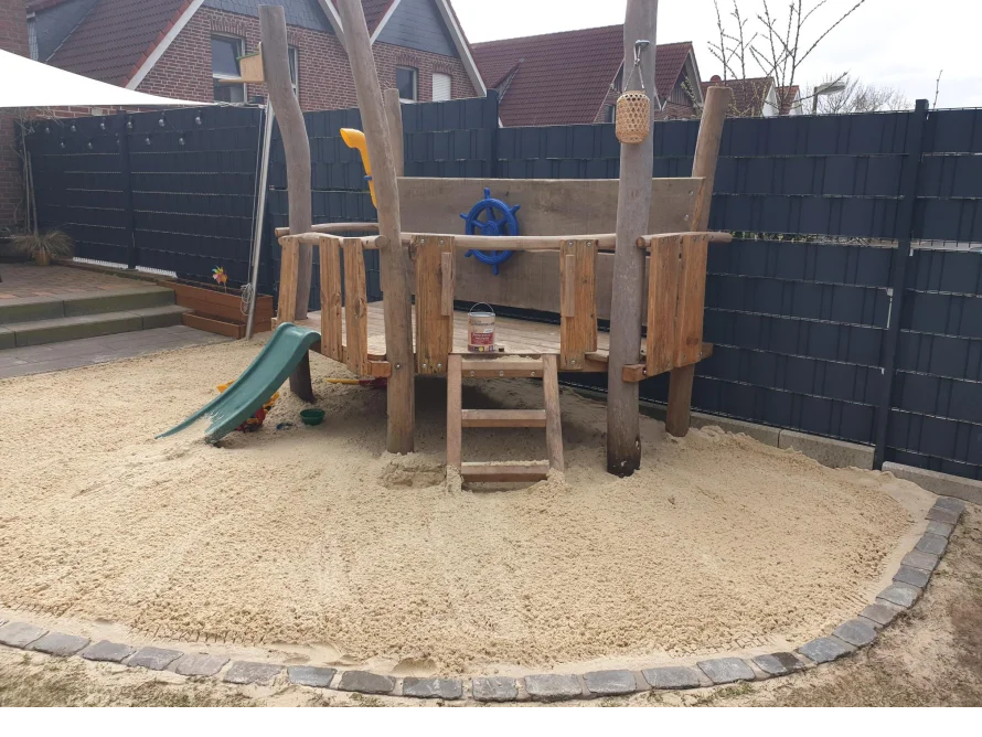 Spielplatz mit Sandkasten und Rutsche