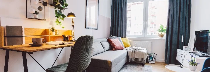 Ein modernes Wohnzimmer mit einem Schreibtisch und einer Couch.