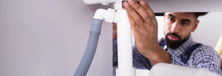 Person repariert Siphon