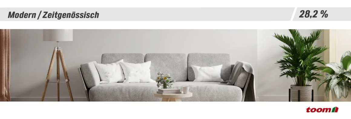 Modern eingerichtetes Wohnzimmer mit grauem Sofa und Pflanzen.