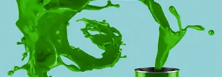Grüne Farbe spritzt aus Farbeimer