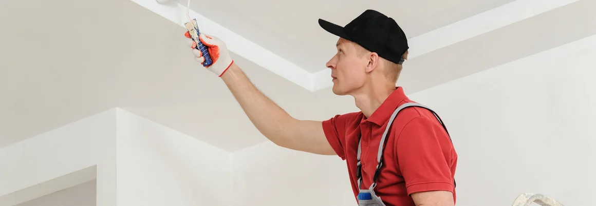 Person streicht Decke weiß